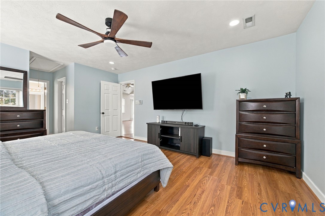 Primary bedroom featuring wood-finish flooring, recessed lighting, and a multi-blade ceiling fan