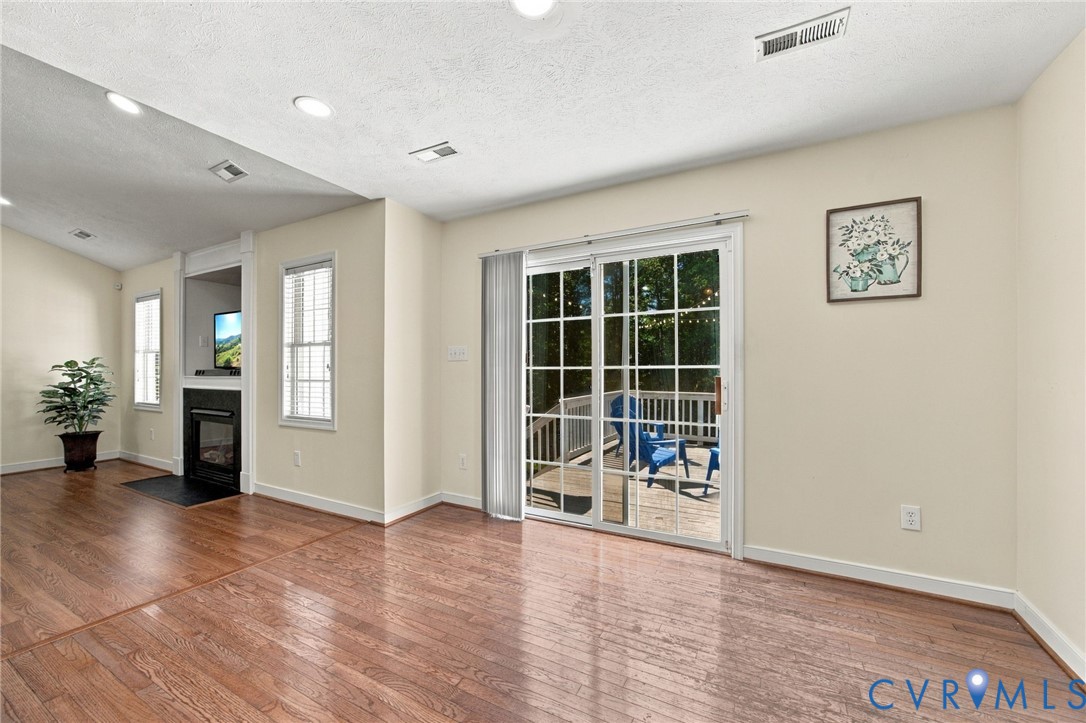Breakfast Area, featuring wood-finish flooring, recessed lighting, a fireplace with a black surround, and glass sliding doors