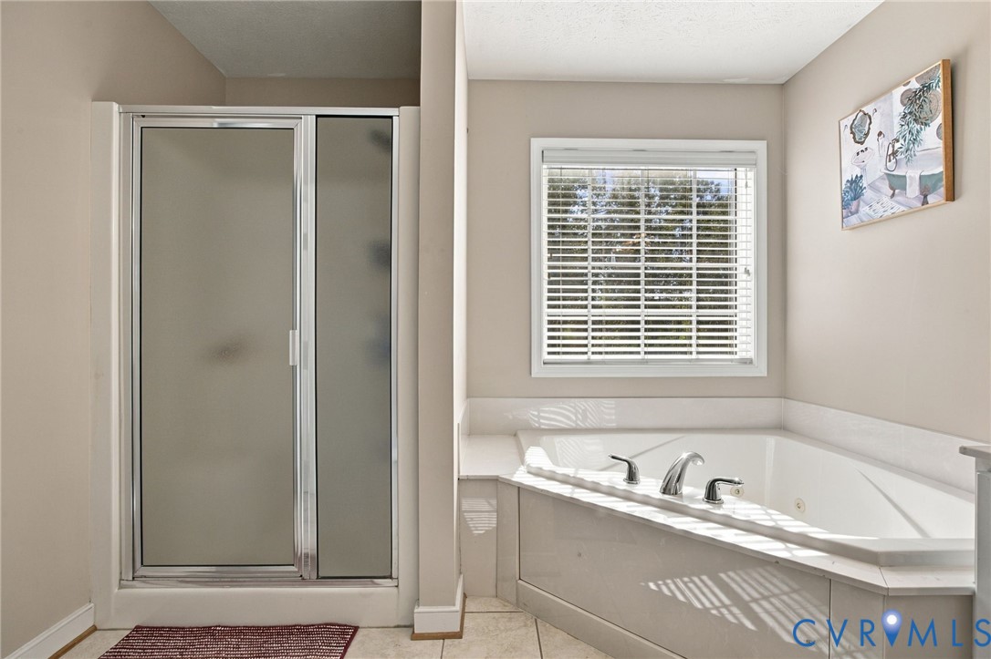 Primary barhroom with Walk-in shower with a frosted glass door, corner soaking tub, integrated deck, and window with horizontal blinds
