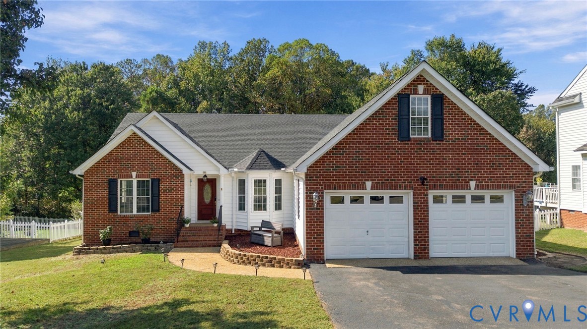 Traditional brick and siding exterior featuring a multi-gabled roofline, front-facing bay window, arched entryway with decorative glass door, and an attached two-car garage Traditional brick and siding exterior featuring a multi-gabled roofline, front-facing bay window, arched entryway with decorative glass door, and an attached two-car garage
