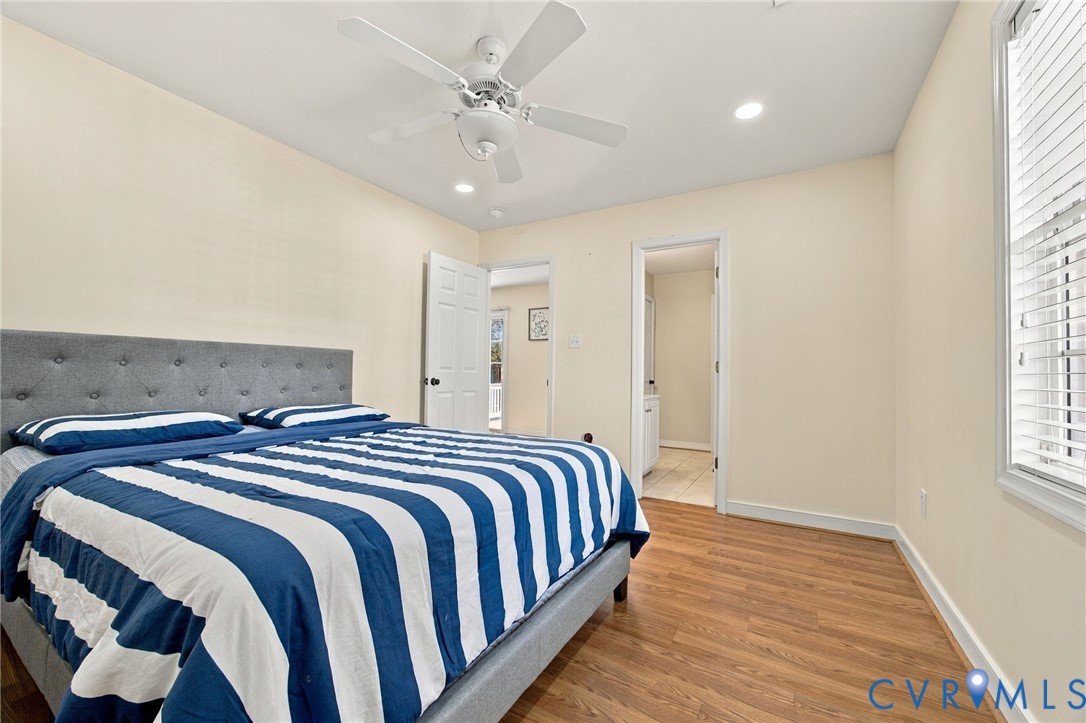 Bedroom with Wood-finish flooring, ceiling fan, recessed lighting, and multi-panel interior doors