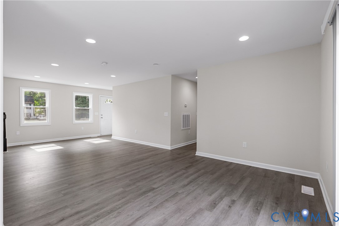 Neutral interior featuring wood-finish flooring, recessed lighting, and multiple windows