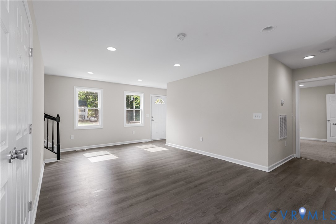 Neutral interior featuring wood-finish flooring, recessed lighting, and crisp wall finishes with clean lines