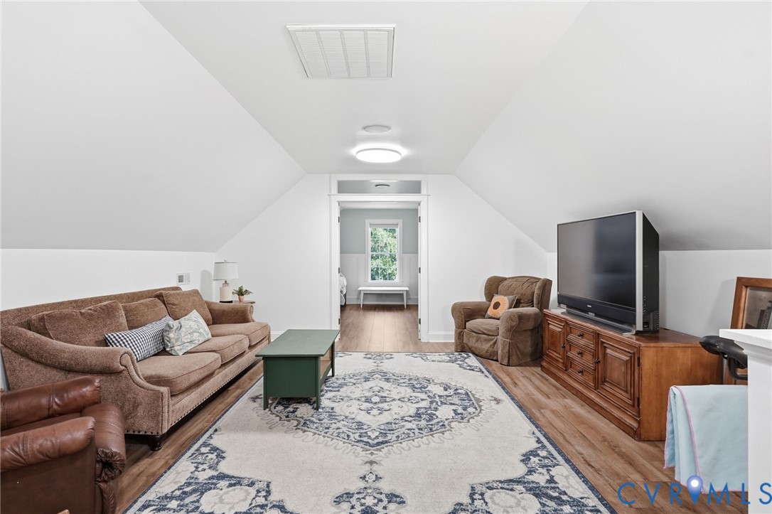 Vaulted ceilings featuring wood-finish flooring and a central doorway with a transom window
