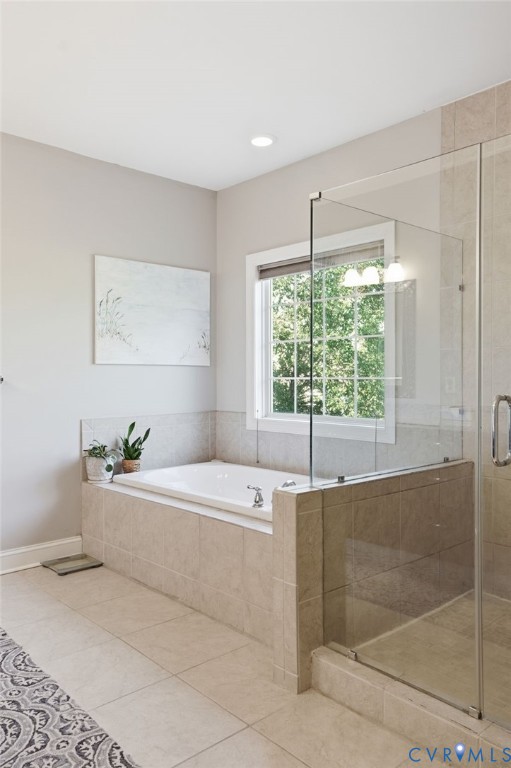 Bathroom featuring a built-in soaking tub with a tile surround, glass-enclosed shower, neutral large-format floor tile, and a window with grid muntins