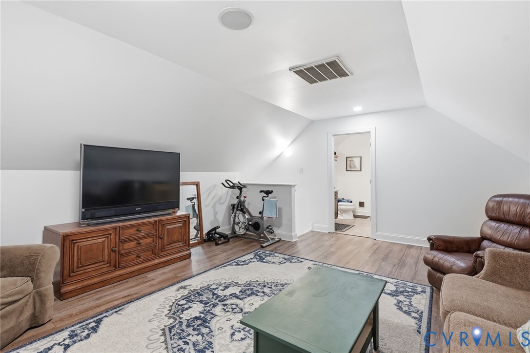 Interior space featuring wood-finish flooring, vaulted ceilings, and recessed lighting