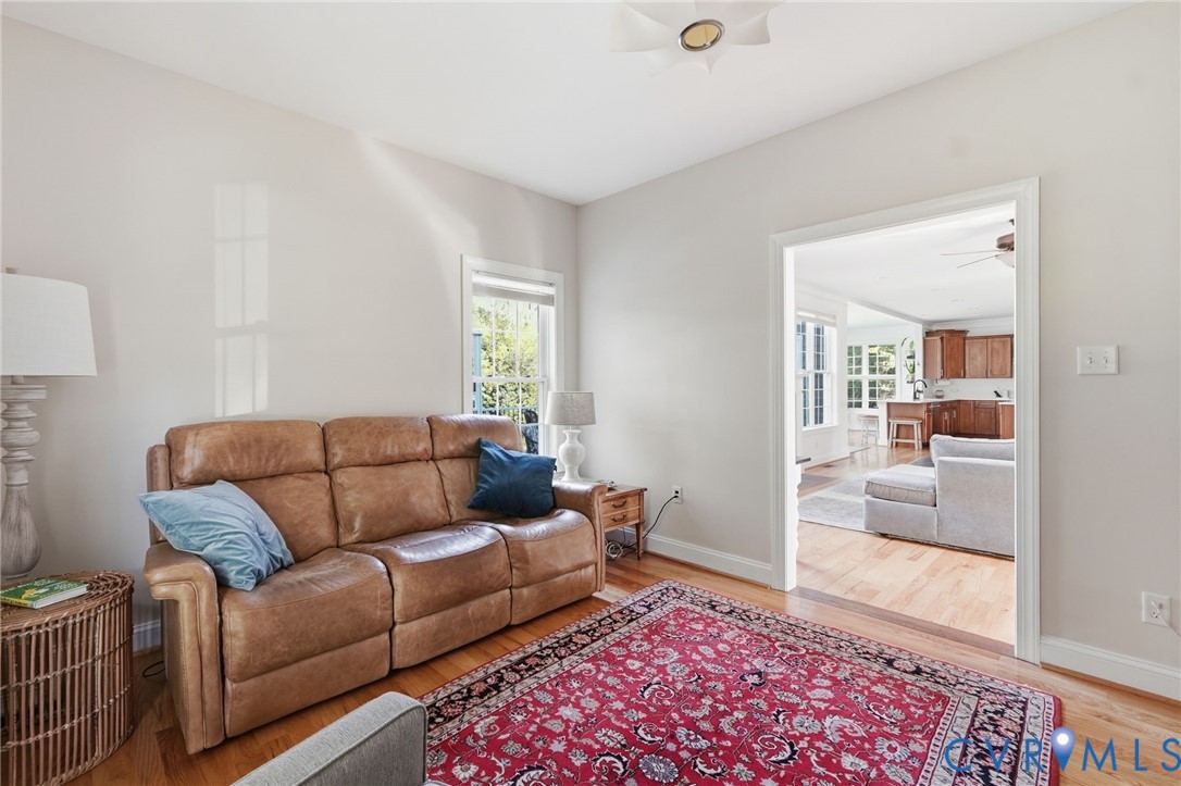 Neutral-toned interior space featuring light-colored walls, wood-finish flooring, and a multi-arm flush-mount ceiling light fixture