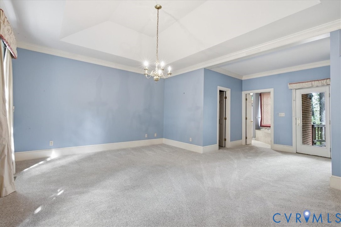 The Primary Bedrooms Suite with Tray Ceiling, Walk-in Closet plus a Second Closet dresses/coats.  Atrium style doors to the Deck and the entrance to the Primary Bath.