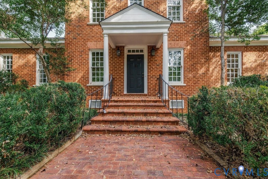 Lovely wide brick walkway to the Front Door. The traditional Williamsburg Colonia style begins here.