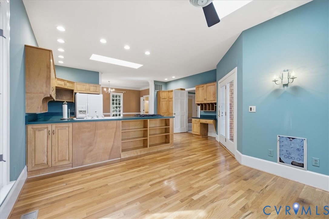 Here you see lots of recessed lighting and skylights.  Beautiful hardwood floors, built in desk and ample counter and cabinet space.