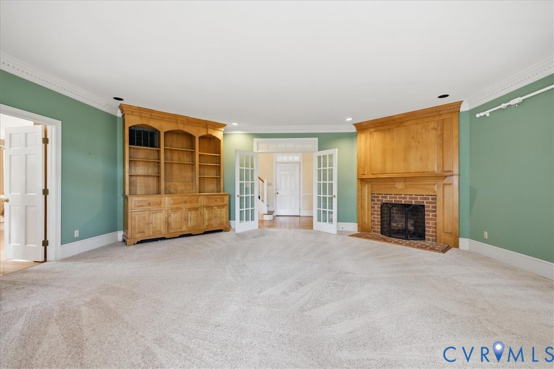 View from the Great Room to the Entry through French Doors.  Custom built fireplace and large custom built cabinet flank the French Doors.