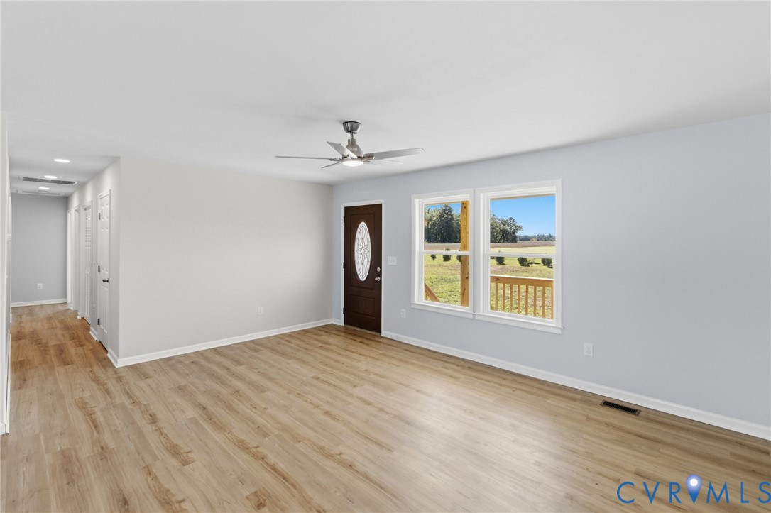 Interior space featuring wood-finish flooring, recessed lighting, a brushed-nickel ceiling fan, and an entry door with an oval glass insert
