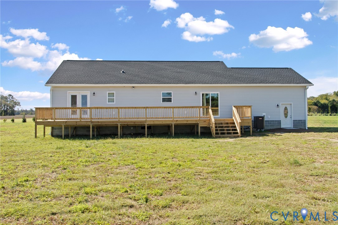Exterior featuring grey vinyl siding, shingle roofing, a sprawling elevated wood deck with railing, and multiple access points including French doors and a sliding glass door