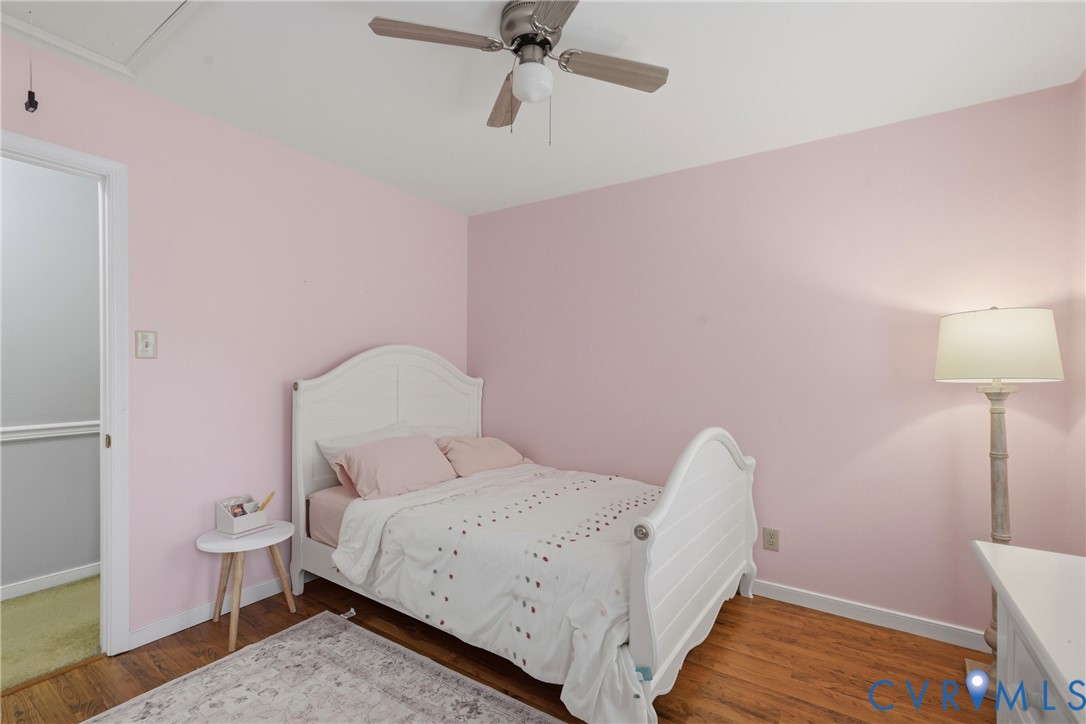 Bedroom featuring wood-finish flooring and a multi-speed ceiling fan with integrated lighting