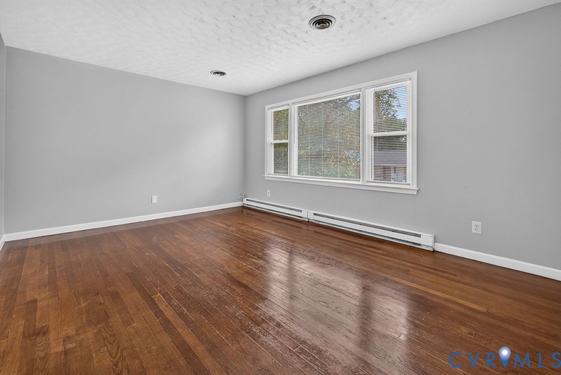 Hardwood flooring, neutral wall paint, and a triple-pane window unit