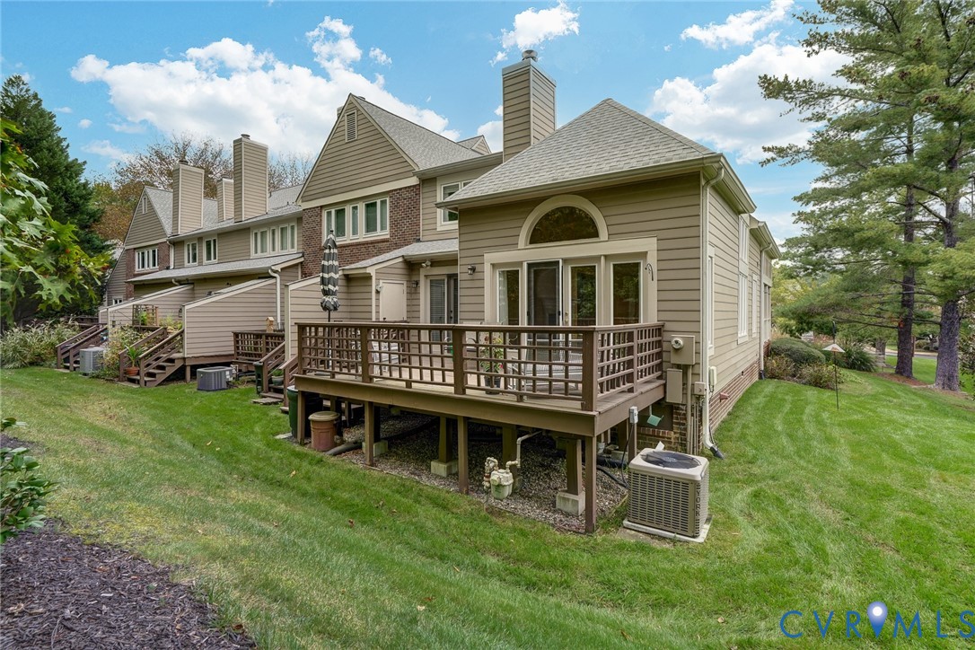Multi-level exterior featuring horizontal lap siding, a brick facade, and an elevated wood deck with perimeter railing