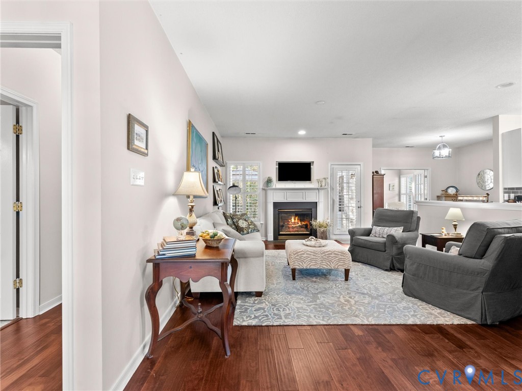 Living area featuring wood-finish flooring, a fireplace with a decorative mantel, and multi-light glass paneled exterior doors