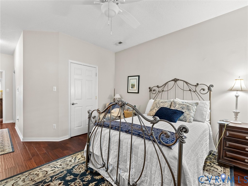 Vaulted ceiling with integrated paddle fan and warm-toned wood-finish flooring