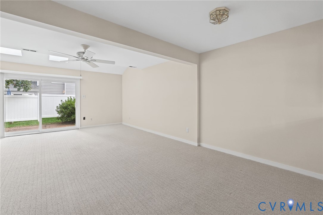 Interior space featuring vaulted ceilings, recessed lighting, a ceiling fan, wall-to-wall carpeting, and sliding glass doors