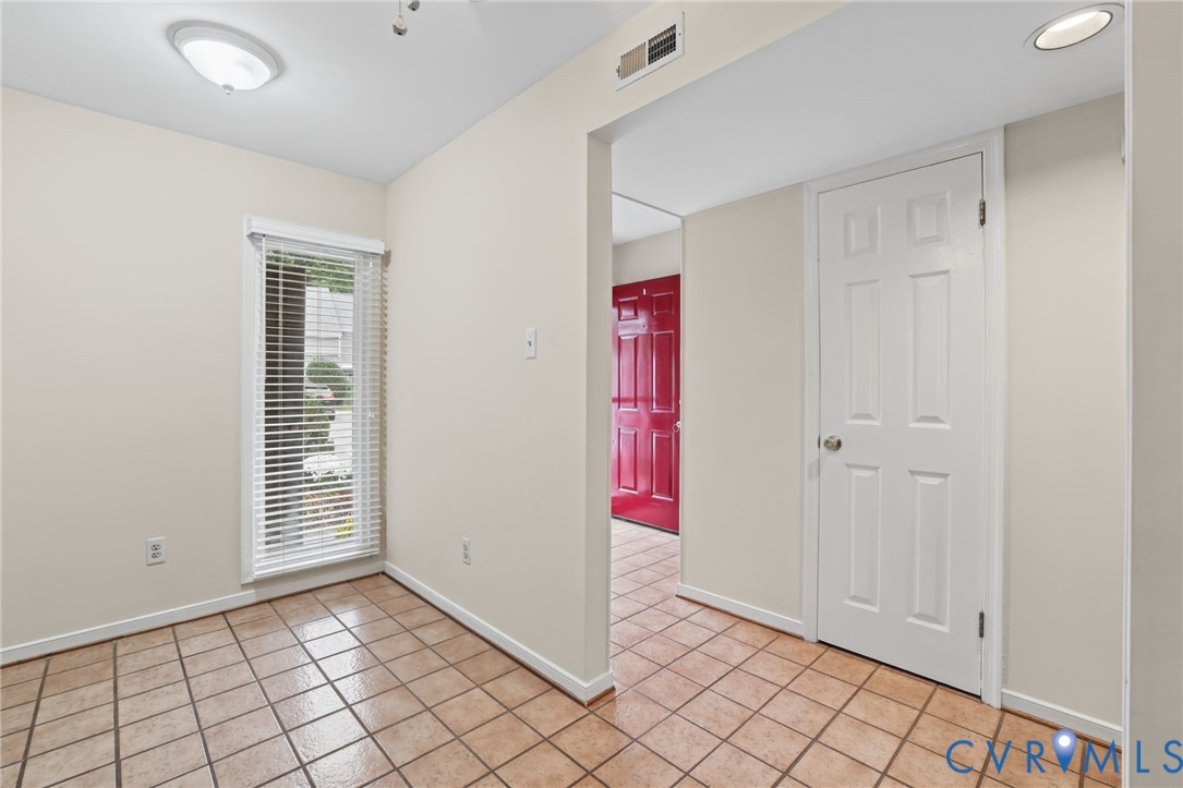 Ceramic tile flooring, neutral wall tones, multi-panel interior door, recessed lighting, and a single-hung window featuring horizontal blinds