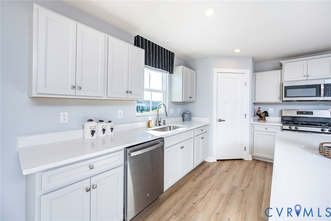 Kitchen featuring white shaker-style cabinetry, gas stove & tons of counter space