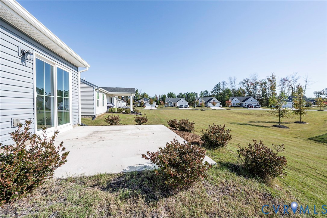 Large Patio overlooking open-space lawn area with established landscaping.
