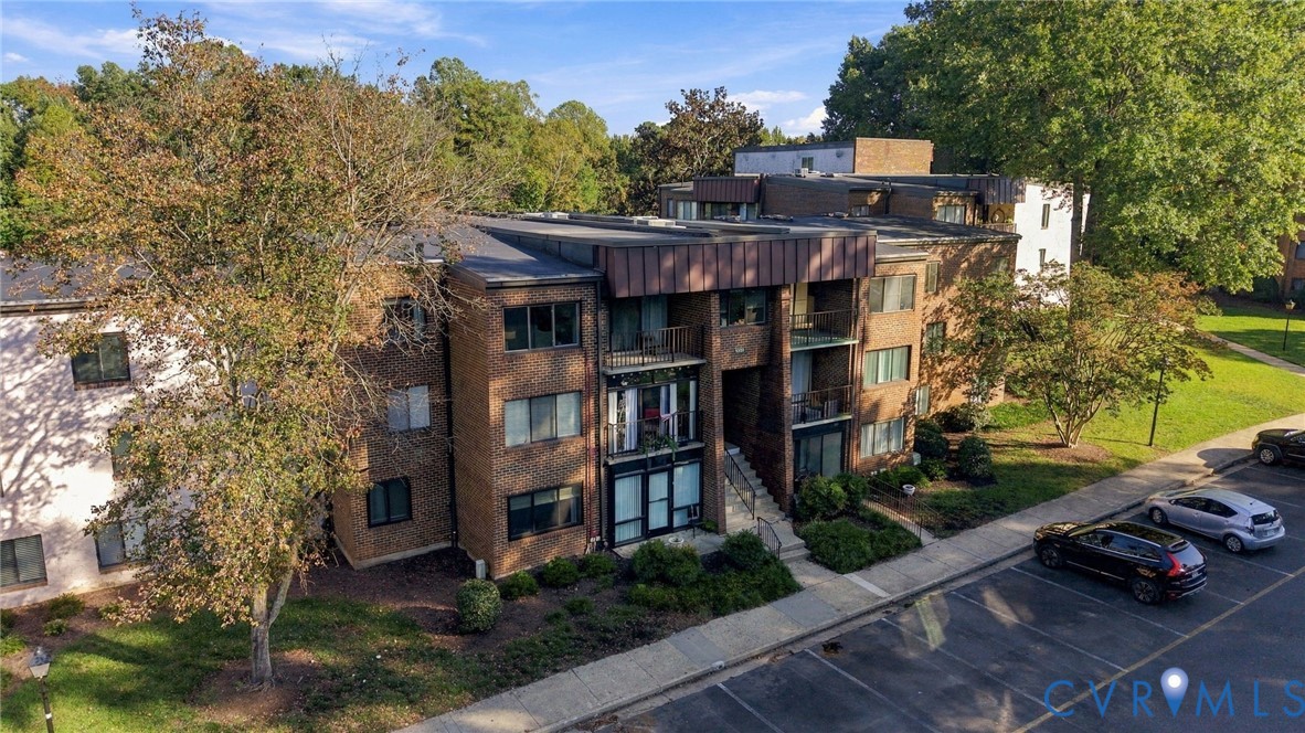 Multi-story brick exterior featuring a flat roofline, metal roof accents, and integrated private balconies