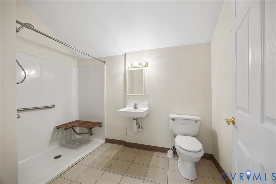 Full ensuite bath with walk-in shower, grab bar and wheelchair accessible sink adjacent to First floor Bed #2