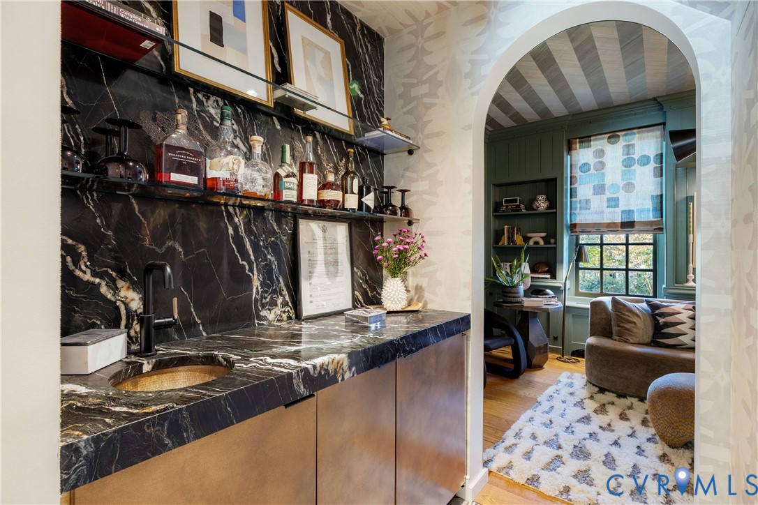 The bar between the kitchen and library has nugget ice, a Perlick beverage fridge, a hand-hammered brass sink and a hidden liquor and electronics closet.