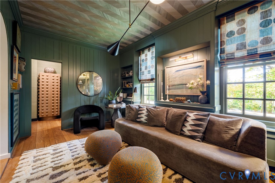 Library/breakfast room with painted wood paneling and built-ins, opening to both the foyer and the bar.