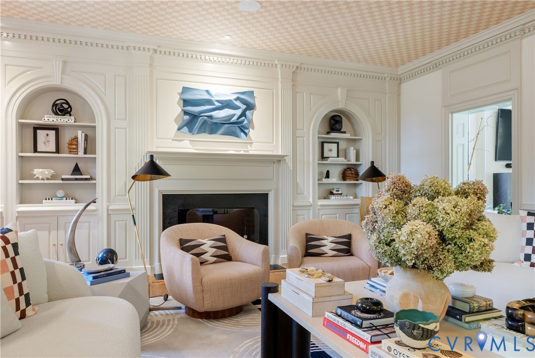 Arched built-ins and original paneling frame the fireplace, with dedicated art lighting and in-ceiling Sonos speakers.