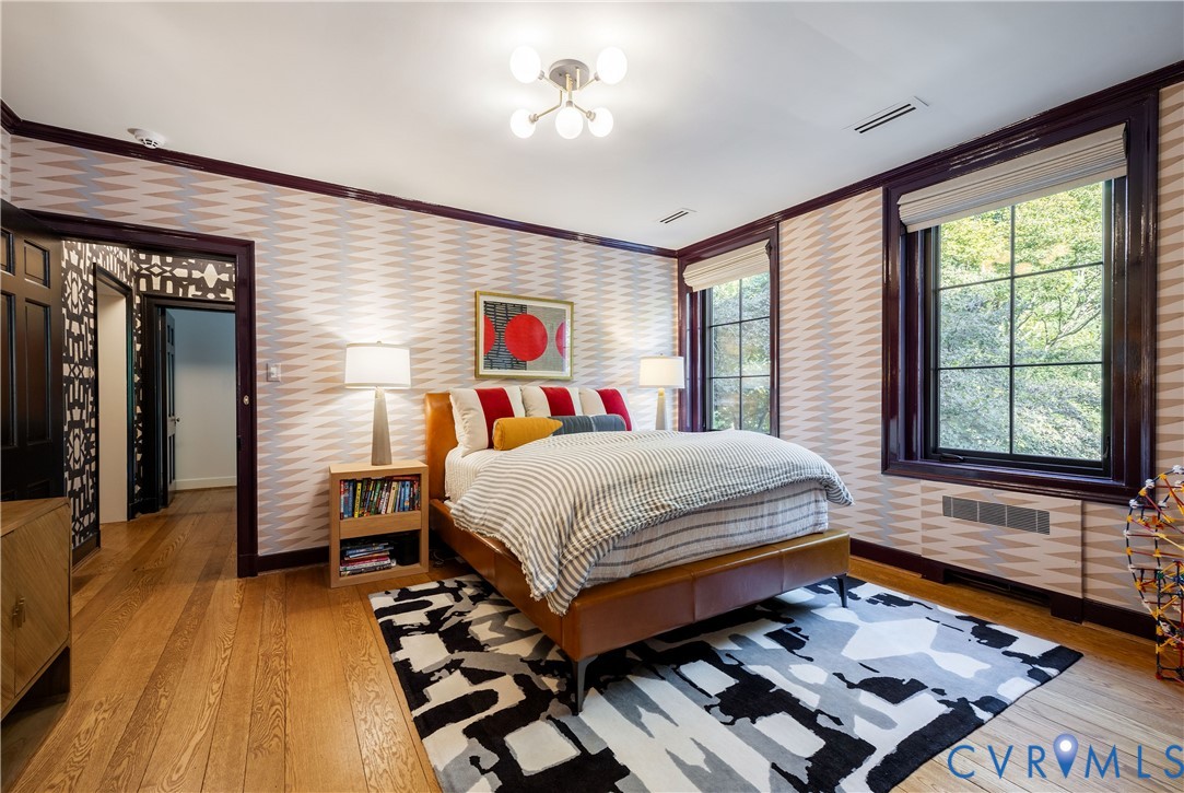 Bedroom with motorized Roman shades, custom built-ins and motion-sensor closet lighting.
