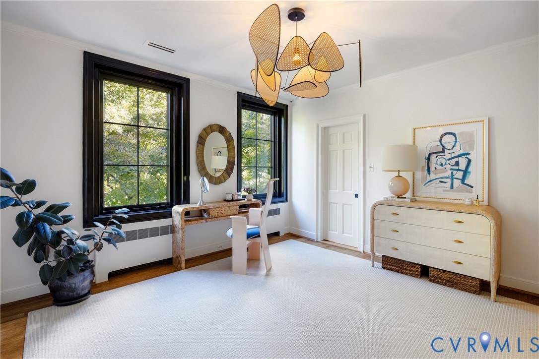 Bedroom adjoining the primary suite, currently styled as a dressing room.
