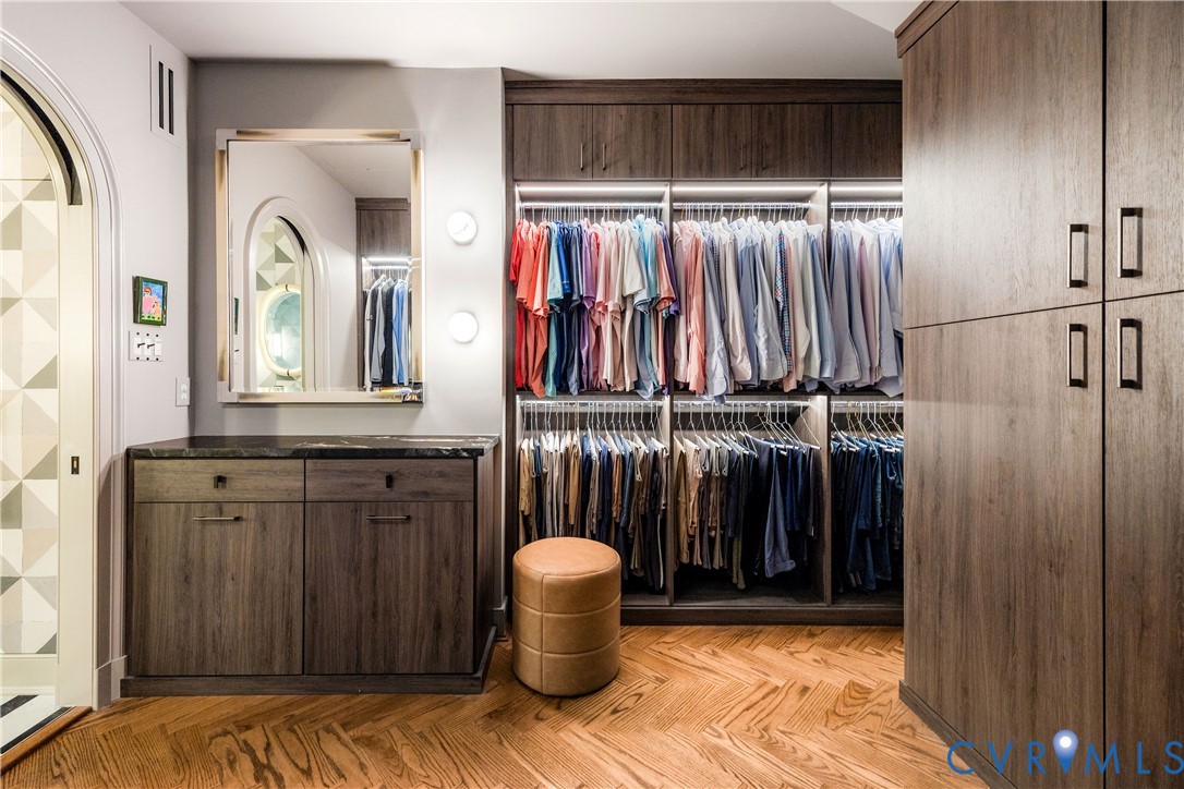 Custom closet with herringbone red oak floors, motion-sensor lighting and a hidden safe.