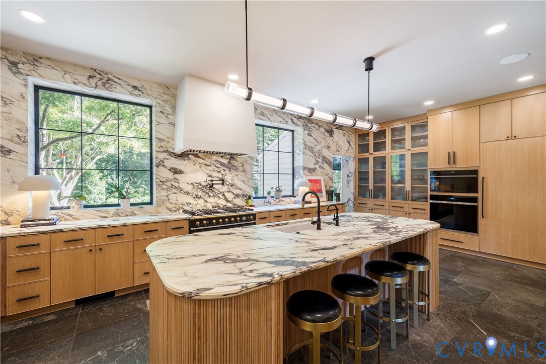 The striking kitchen wrapped in Calacatta Viola marble with a hand-reeded white oak island.