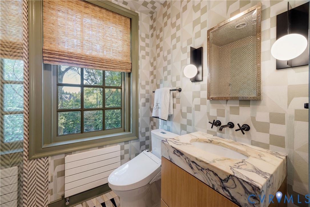 En suite bath with a frameless glass shower, white oak vanity and Calacatta Viola top.