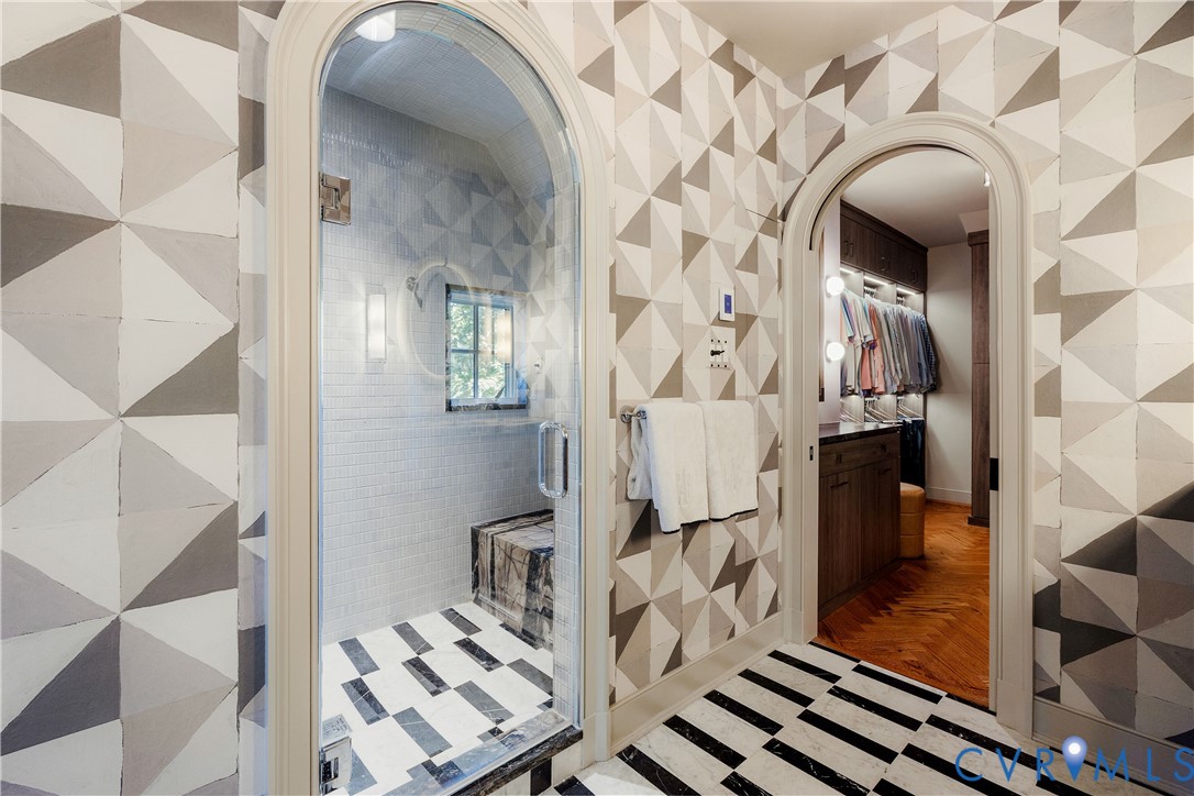 Steam shower with a shower dryer and arched glass door, beside a new arched doorway to the closet.