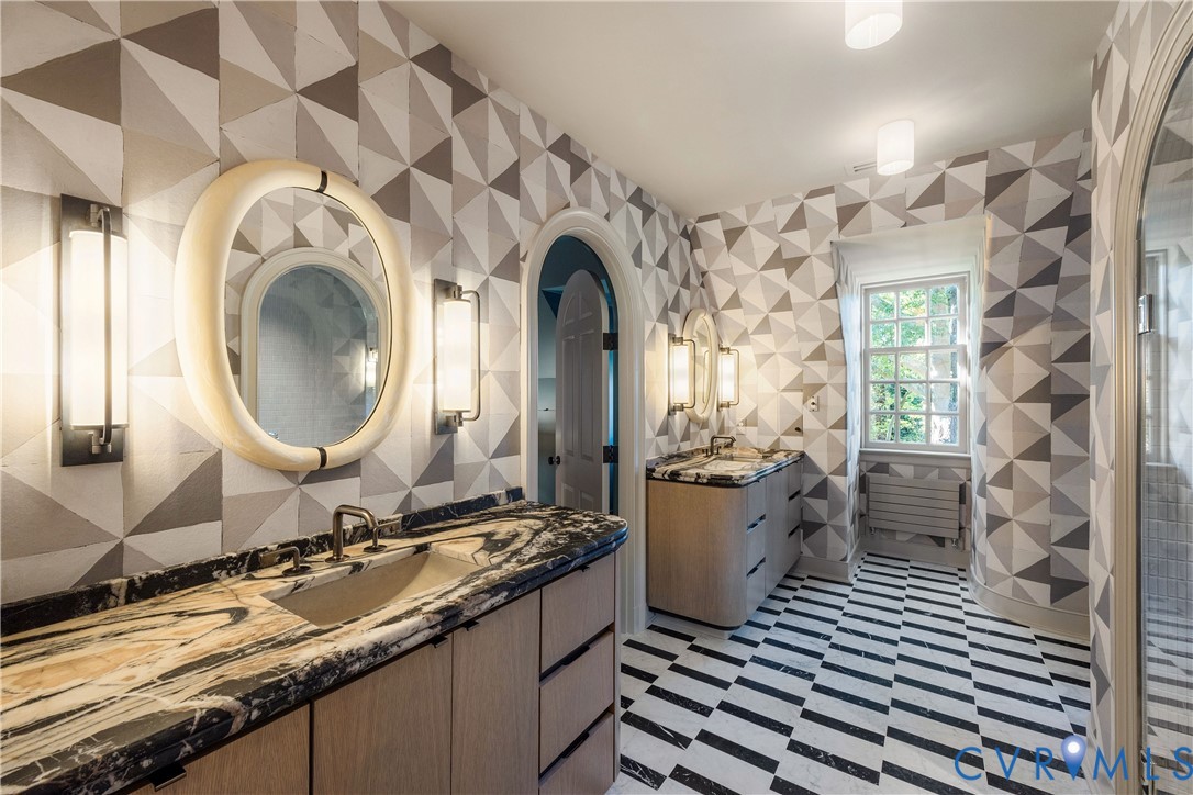 Primary bath with custom white oak radius vanities, a heated marble floor and storage hidden flush in the walls.