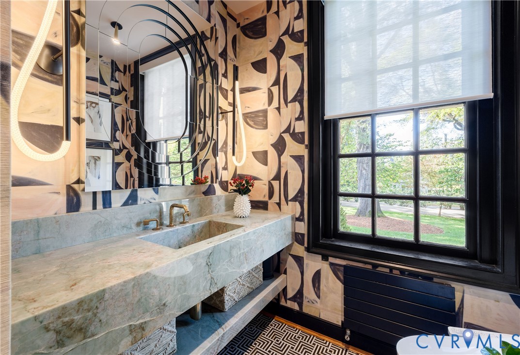 Powder room with a custom wall-to-wall integrated stone sink, Luke Lamp Co. lighting and Lindsay Cowles grasscloth.