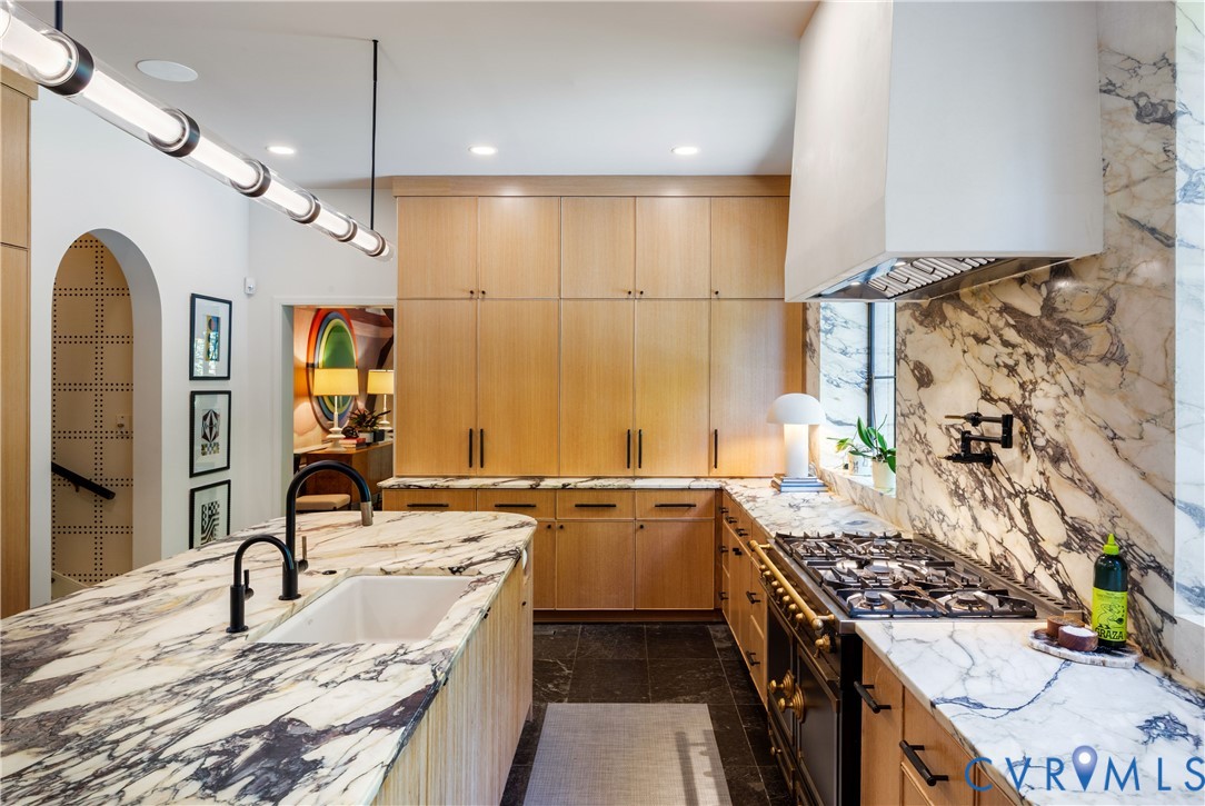Paneled white oak conceals a 36-inch Sub-Zero refrigerator and 30-inch freezer, with reverse osmosis water at the sink.