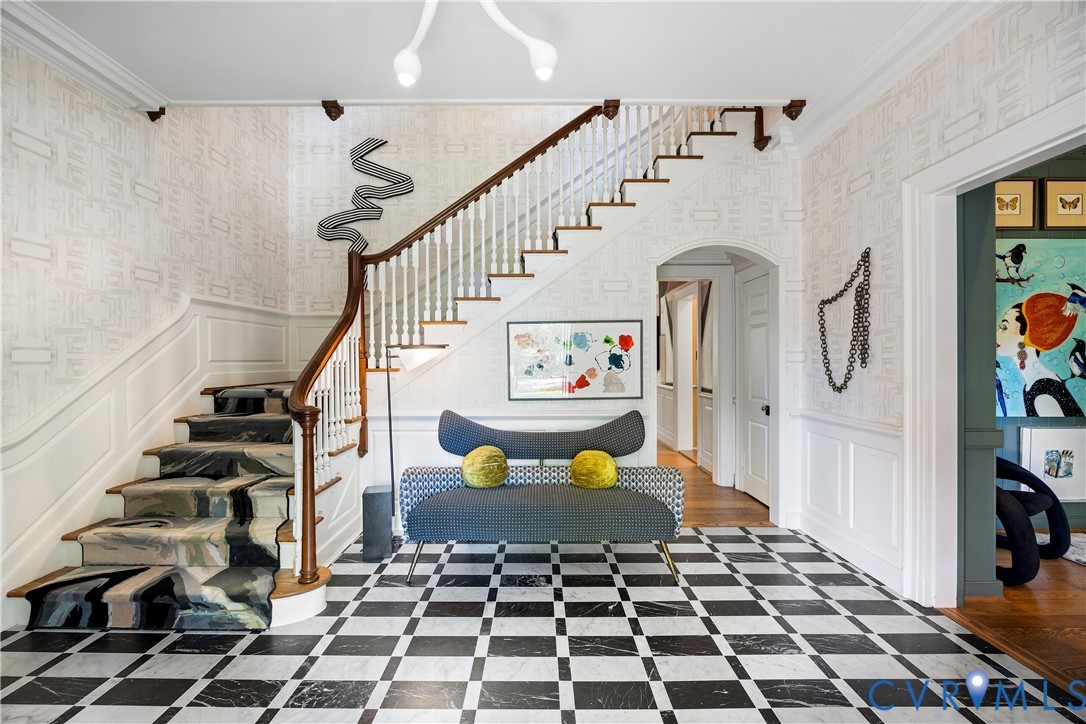 Entry foyer with heated marble floors, 10-foot ceilings, and a hand-loomed stair runner and wallpaper.