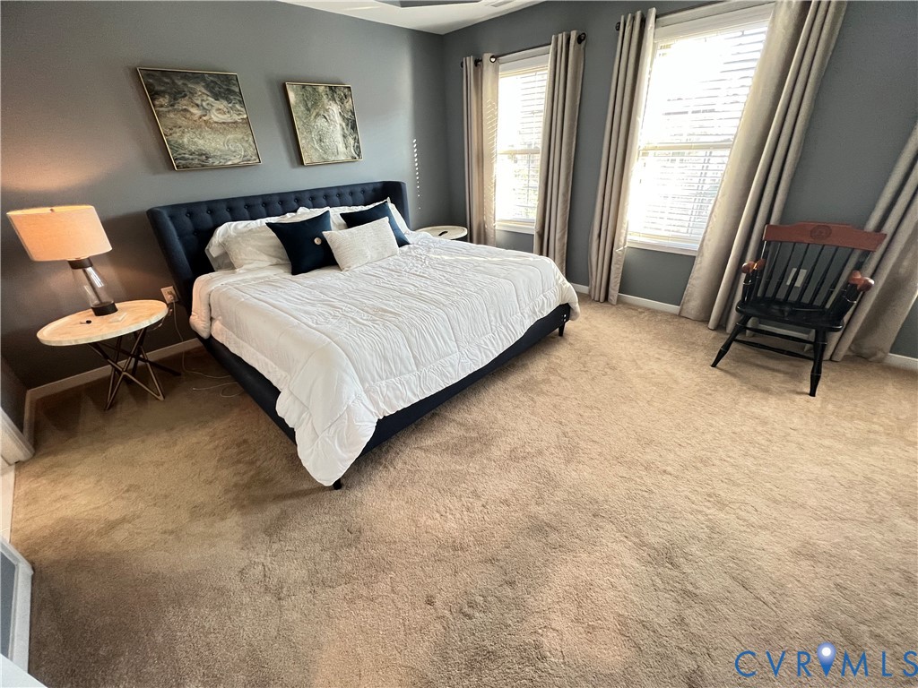 Spacious room featuring neutral carpeting, dual windows with integrated blinds, and light-toned wall paint