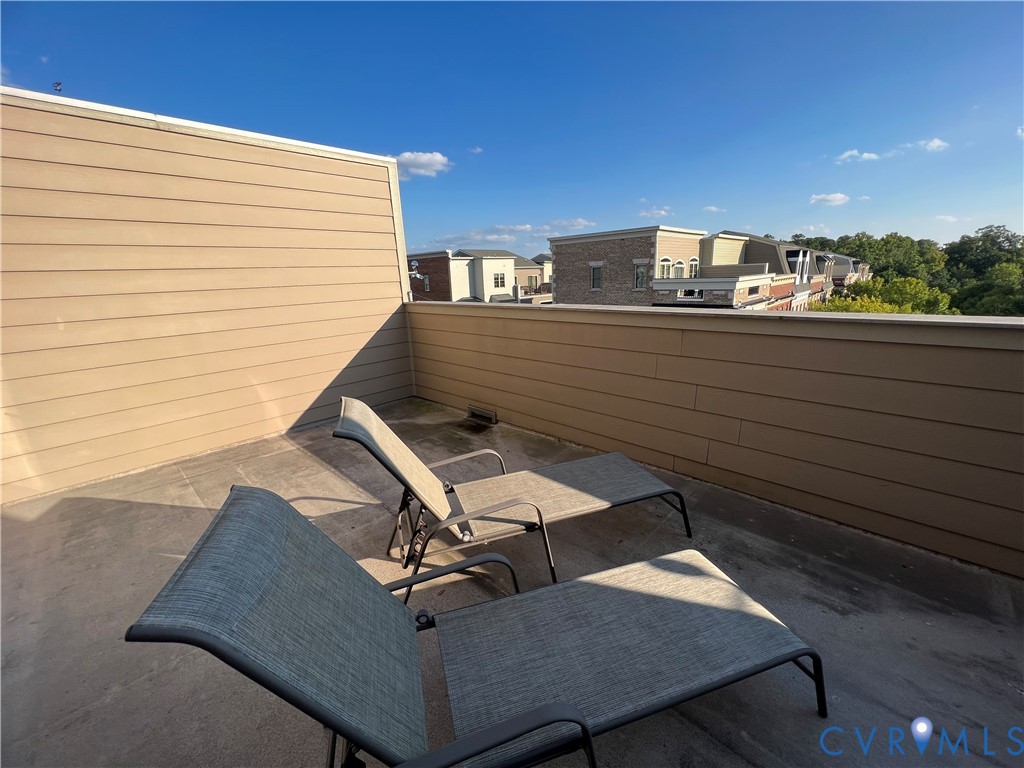 Rooftop terrace featuring horizontal lap siding, flat concrete flooring, and surrounding parapet walls
