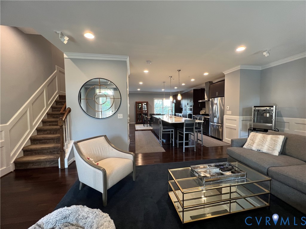 Open-concept interior featuring dark hardwood flooring, recessed lighting, and a kitchen island with stone countertops