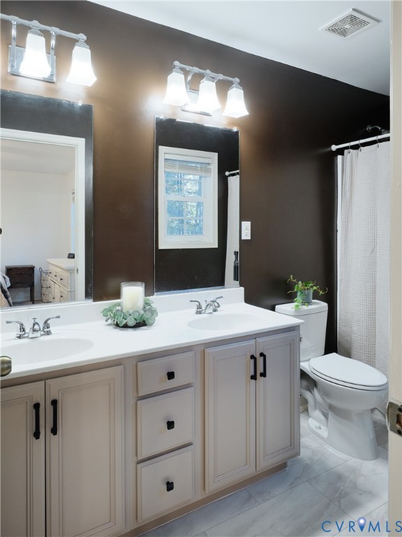 Beautifully remodeled bathroom with dual vanitites.