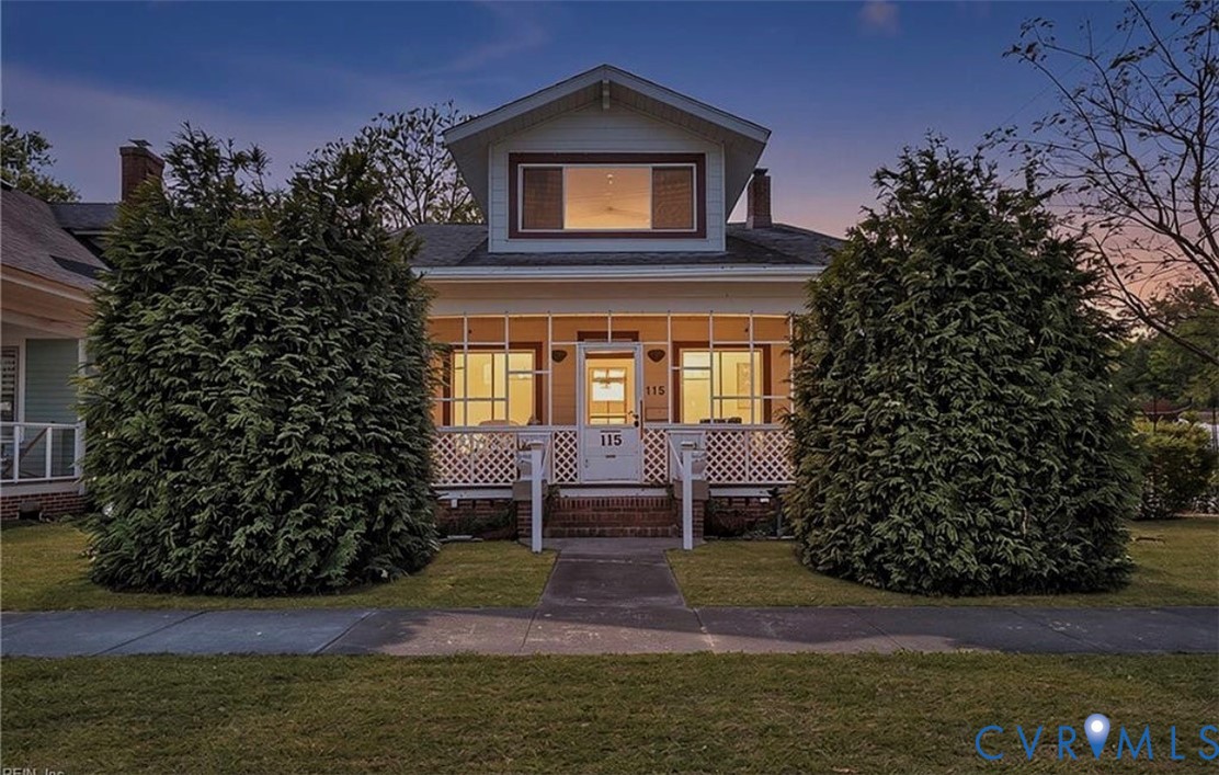 Craftsman-style exterior featuring a covered front porch, white lattice railing, gabled roofline, and brick stair risers