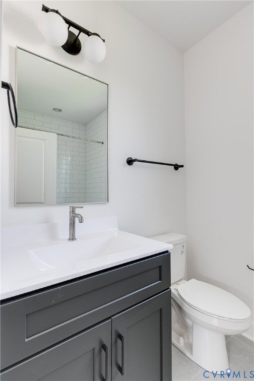 Dark gray vanity with a crisp white countertop, integrated sink, matte black hardware, dual-globe vanity light, and a framed mirror
