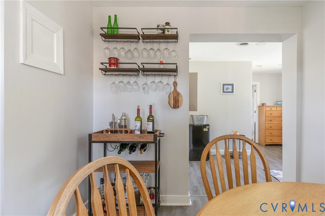 Wall-mounted metal and wood-finish shelving with integrated stemware racks and wood-finish flooring