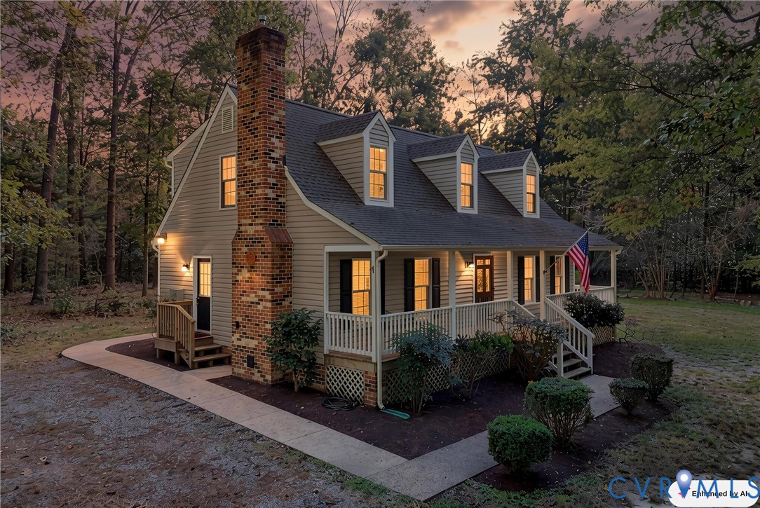 Exterior featuring horizontal siding, a prominent brick chimney, three dormer windows, a covered front porch with railings, and a concrete walkway