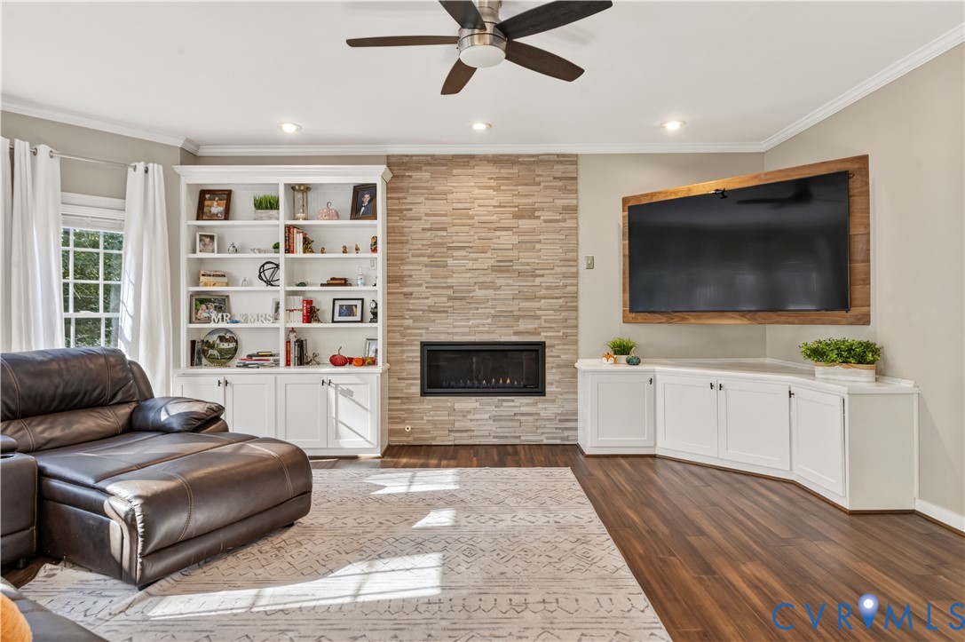 Family room features bamboo floors, recessed lighting, custom built-in wall fireplace and surrounded by custom cabinetry.